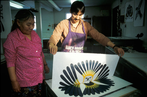 Kenojuak Ashevak and Kavavaow Mannomee in the process of creating the print The Sun's Return, created by the stonecut and stencil technique