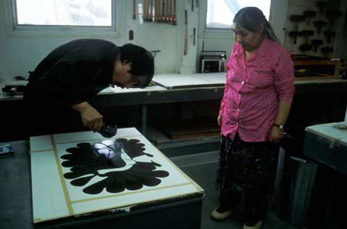 Kenojuak Ashevak and Qiatsuq Niviaqsi in the process of creating the print 'Audacious Owl', created by the stonecut and stencil technique