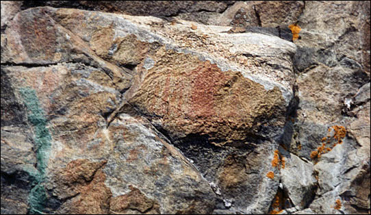 A faded pictograph painted on a rock.