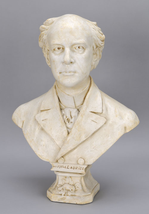 White plaster bust of Sir Wilfrid Laurier, attributed to Alfred Laliberté. The name "Wilfrid Laurier" is carved into the base at the front. Canadian Museum of History, 2011.21