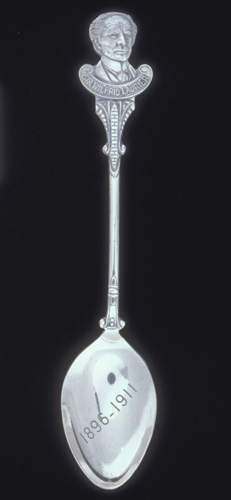 Silver commemorative spoon with handle in the shape of Sir Wilfrid Laurier's head. Canadian Museum of History, 1999.124.85