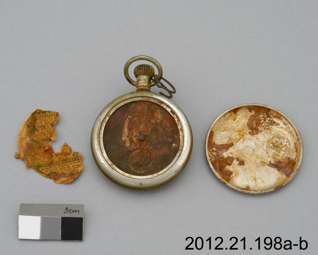  The largest label fragment is shown on the left side of picture, before treatment. This fragment was originally set inside the lid, which covers the reverse side of the watch.