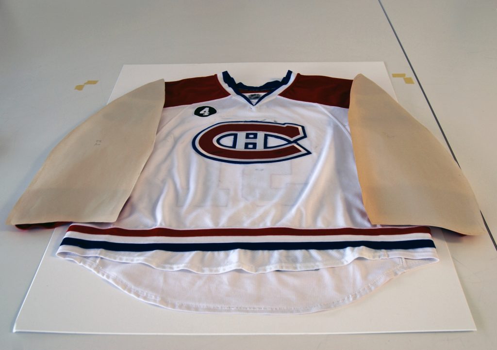 Paper patterns were created by tracing the shapes of the arms and body of the jersey. These were then used to make the matboard inserts that help to support the jersey and provide the desired shape. Photo: Canadian Museum of History. 