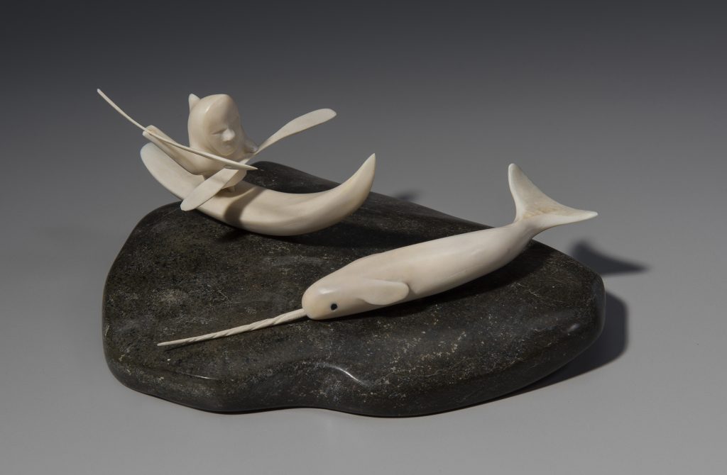 Sculpture of a person hunting a narwhal by kayak