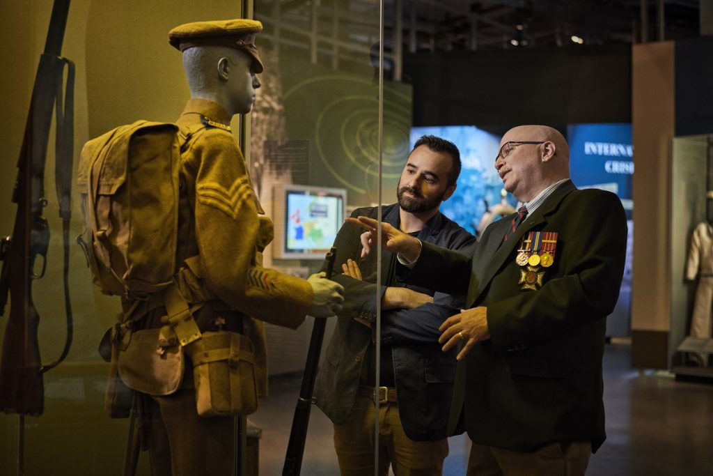 Visitors looking at a uniform in War Museum Gallery