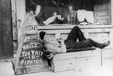 Man sleeping outside his store, The Ward