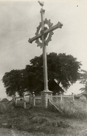 Croix de chemin avec extrémités à décor treflé avec coq à la cime et couronne. Boucheville, Québec, [191-]., © MCC/CMC, Edouard Zotique Massicotte, B556-10.16