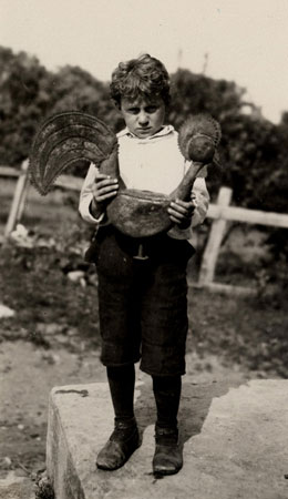 Jeune garçon de la famille Lemelin tenant un coq de girouette en métal, Saint-François, Québec, 1925., © MCC/CMC, Marius Barbeau, 65769