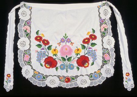 White cotton apron with multi-coloured embroidered floral motif, cut work and eyelet embroidery., © CMC/MCC, 76-514.3