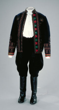This jacket is part of a costume that is usually worn in Verbunk or Legenyes dances. It is made with navy blue wool and embroidered with green and red colour, and decorated with a floral tulip motif and black beads., © CMC/MCC, 89-4.3
