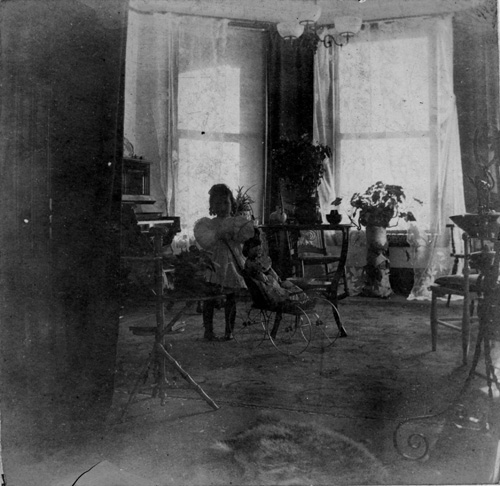 Full length portrait of Marjorie Edith Holcroft daughter of Charles and Edith Holcroft photographed with her doll in the drawing room of her home in Toronto, Ontario
