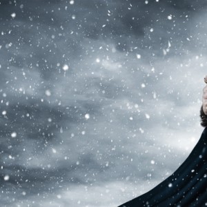 A man in a viking costume is standing in the snow, portraying the true spirit of Vikings.