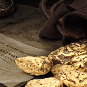 Gold truffles on a wooden table with a compass.
