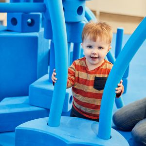 Child with big blue foam blocks