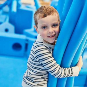 Child with big blue foam blocks