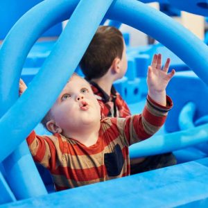 Child with big blue foam blocks