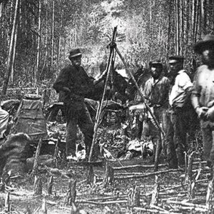 A group of men standing in a wooded area