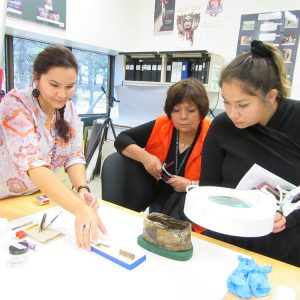 Three women looking at an artifact