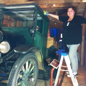 A woman cleaning an old car