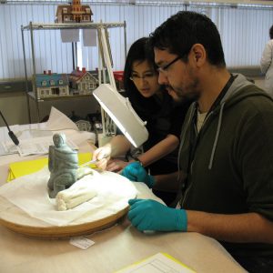 A man and woman examine an artifact.