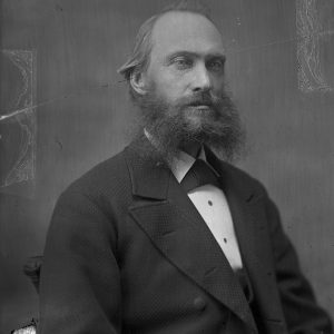 Black-and-white photograph of a bearded man in a suit