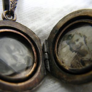 Tarnished locket with a photo of a woman on the right side