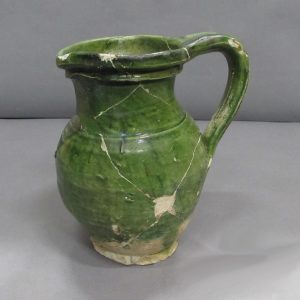Cracked ceramic jug with a handle and green glaze