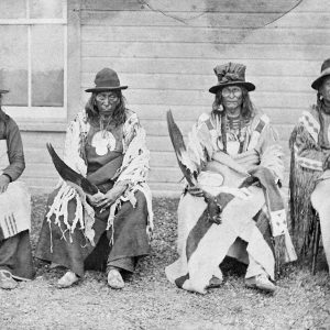 Black-and-white photograph of four seated Indigenous men