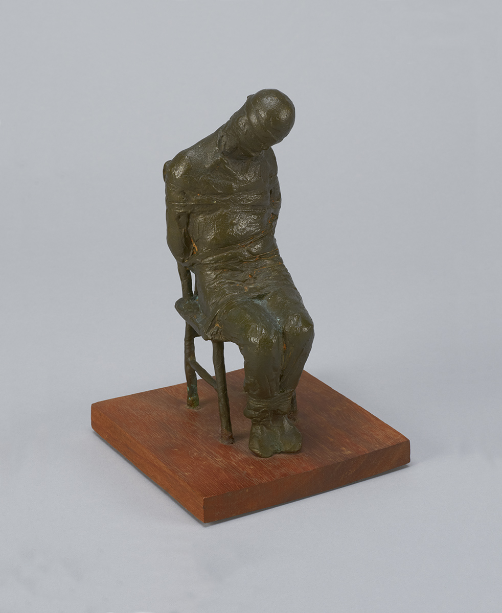 A bronze sculpture of a man sitting on a chair displayed at the Canadian Museum of History in Ottawa.
