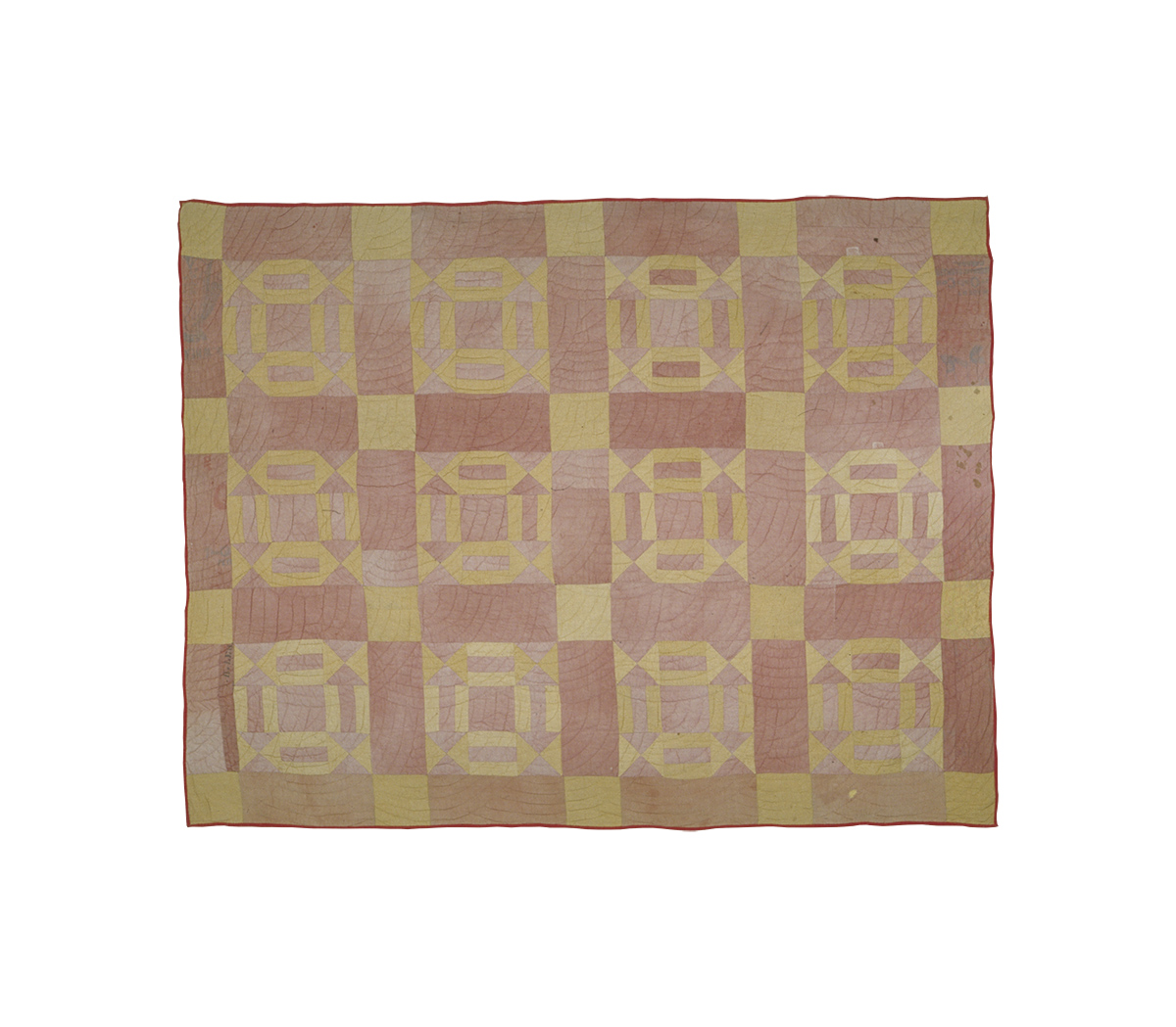 A pink and yellow quilt with squares on it displayed at the Canadian Museum of History in Ottawa.