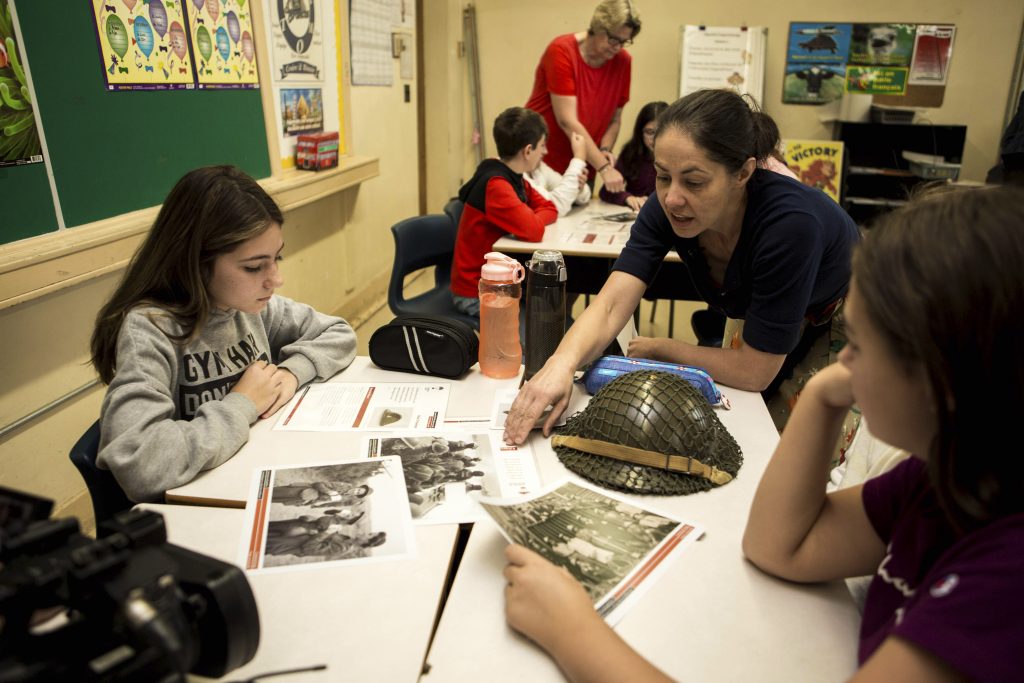 Students looking at artifacts from the Discovery Box in a classroom 