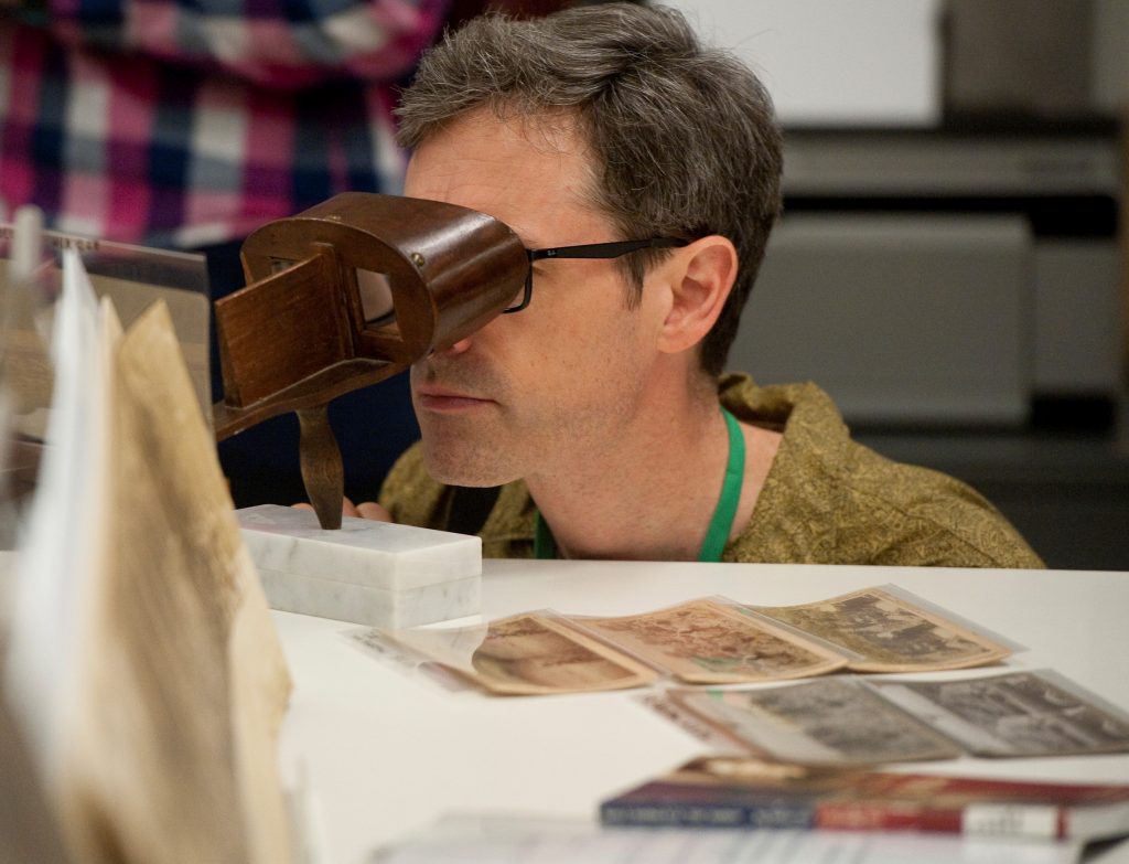 A historian looking at old war photographs.