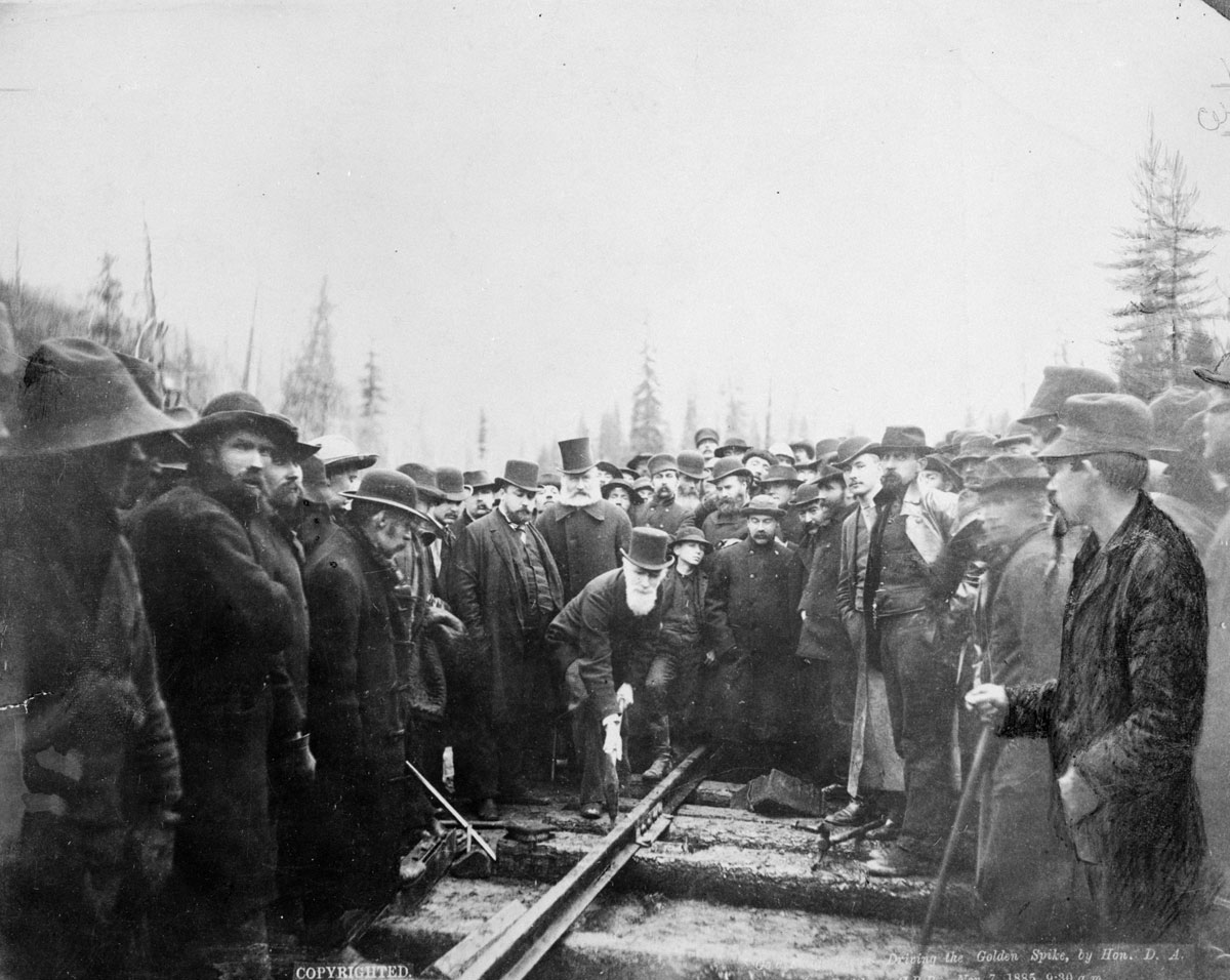 A group of people standing and finishing the a train track
