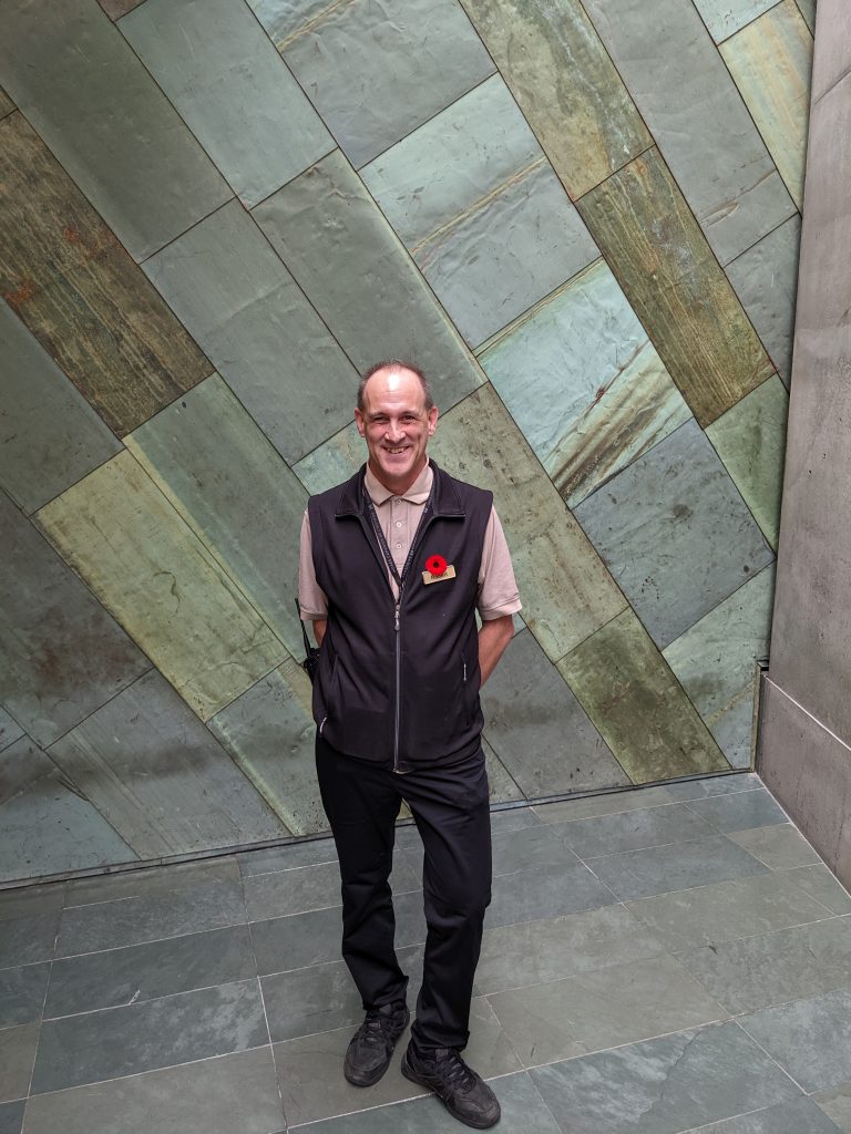 Rob, a History Buff, standing in front of a tiled wall.