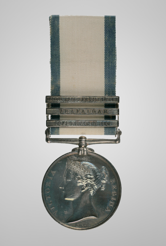 A silver coloured medal on a ribbon decorated with three engraved metal bars.