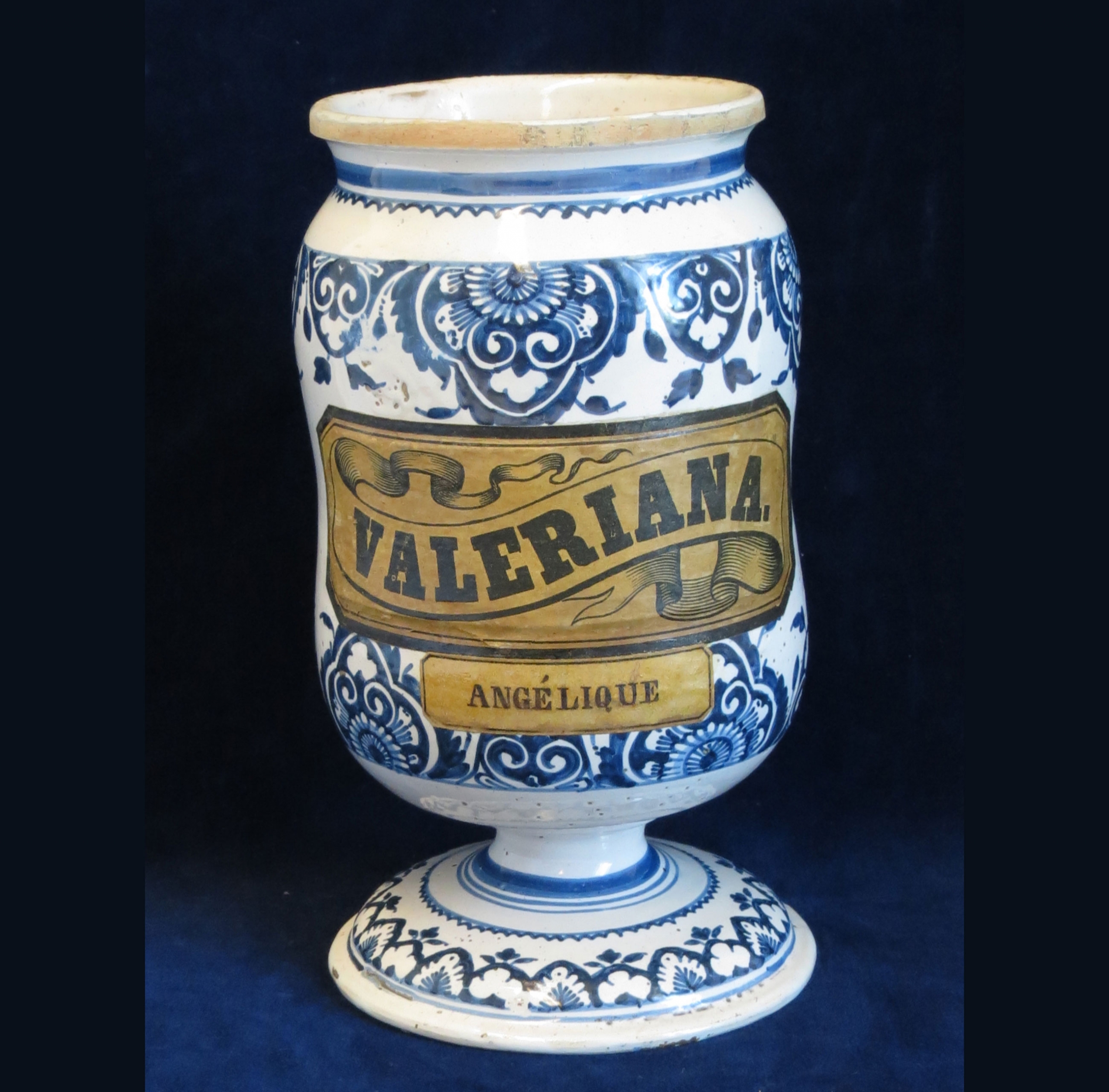 Photo of antique pharmacy pot made of blue and white ceramic. Label reads 'Valeriana - Angélique'