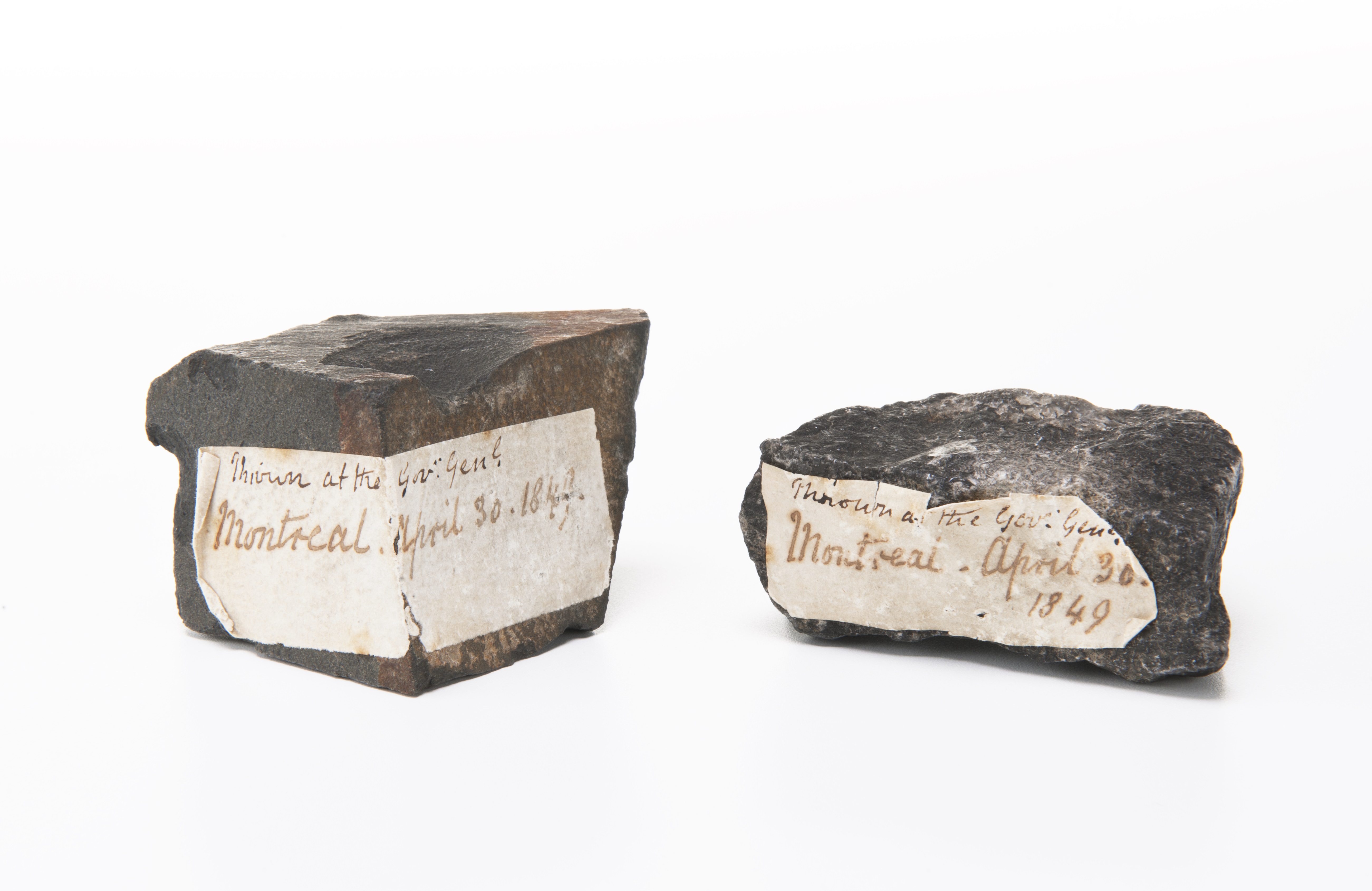two rocks with dated labels on them. 