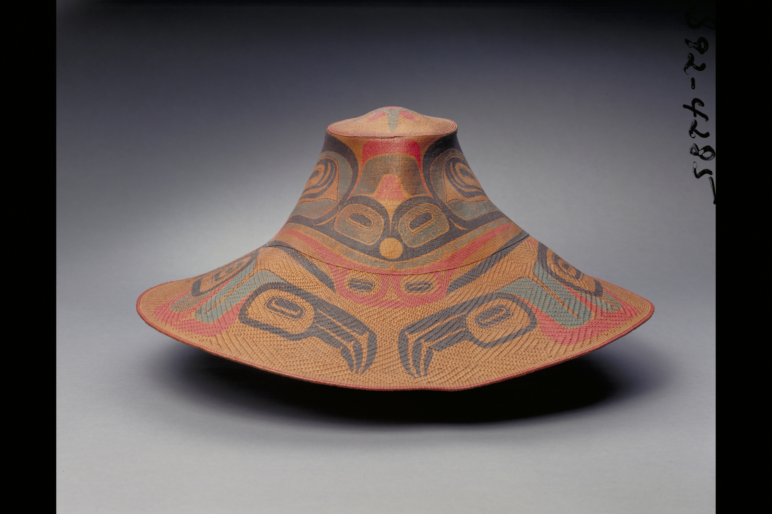large hat woven of spruce roots with a formline animal design painted on