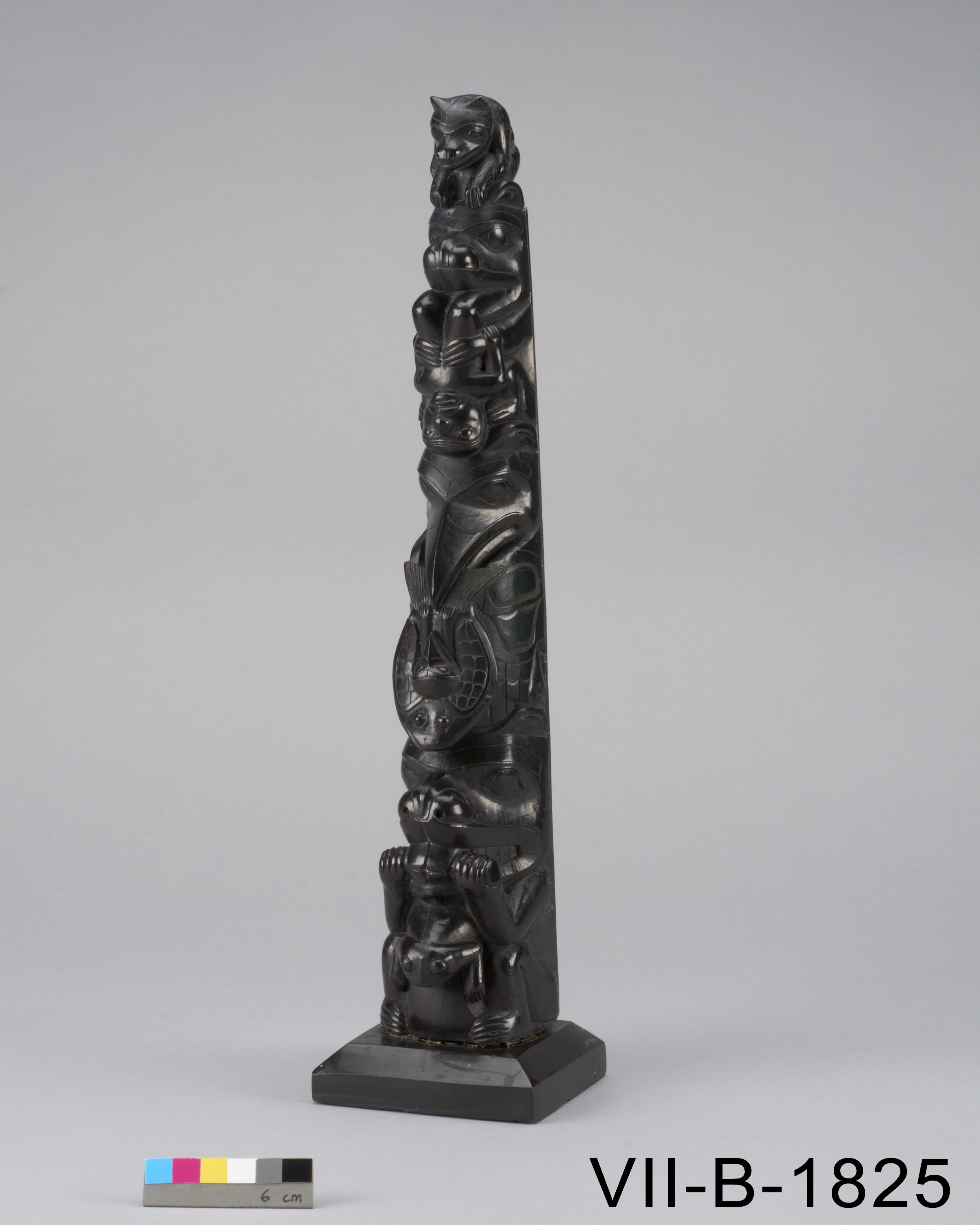 small black sculpture of a totem pole featuring animals