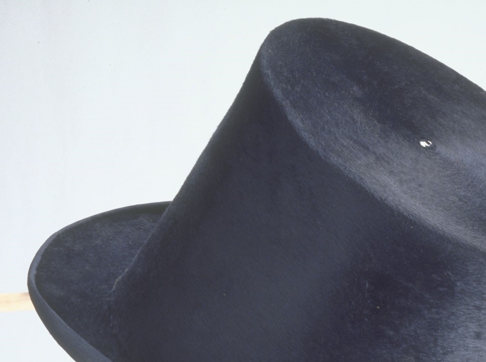 Tall, black top hat on a mannequin head