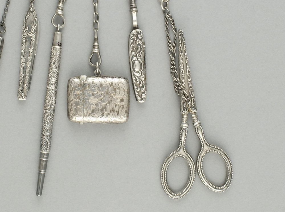 Châtelaine en argent sur fond gris. //Silver chatelaine on grey background