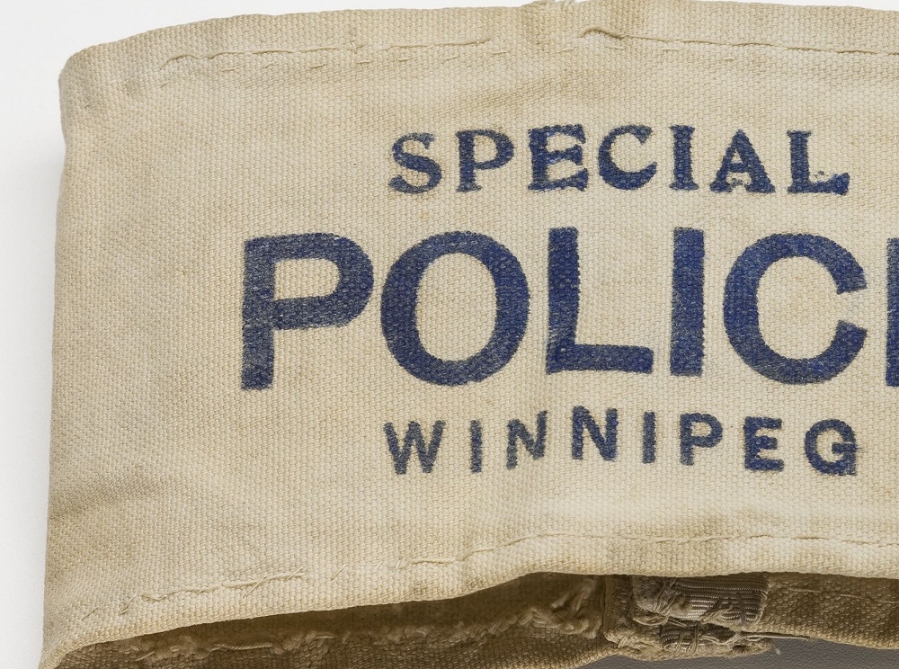 Brassard en coton blanc portant l’inscription « Special Police Winnipeg » (Police spéciale Winnipeg).//White cotton armband with “Special Police Winnipeg” on it