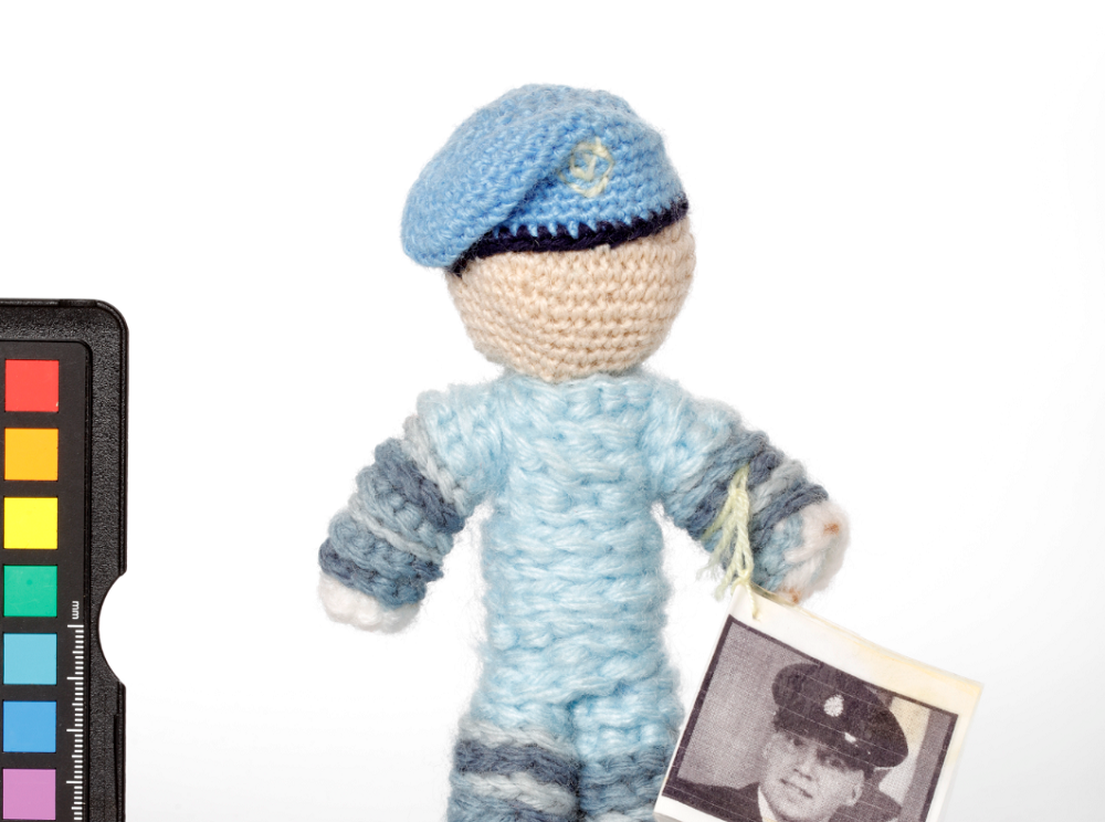 Petite poupée tricotée représentant un gardien de la paix canadien.//Small knitted doll to look like a Canadian peacekeeper