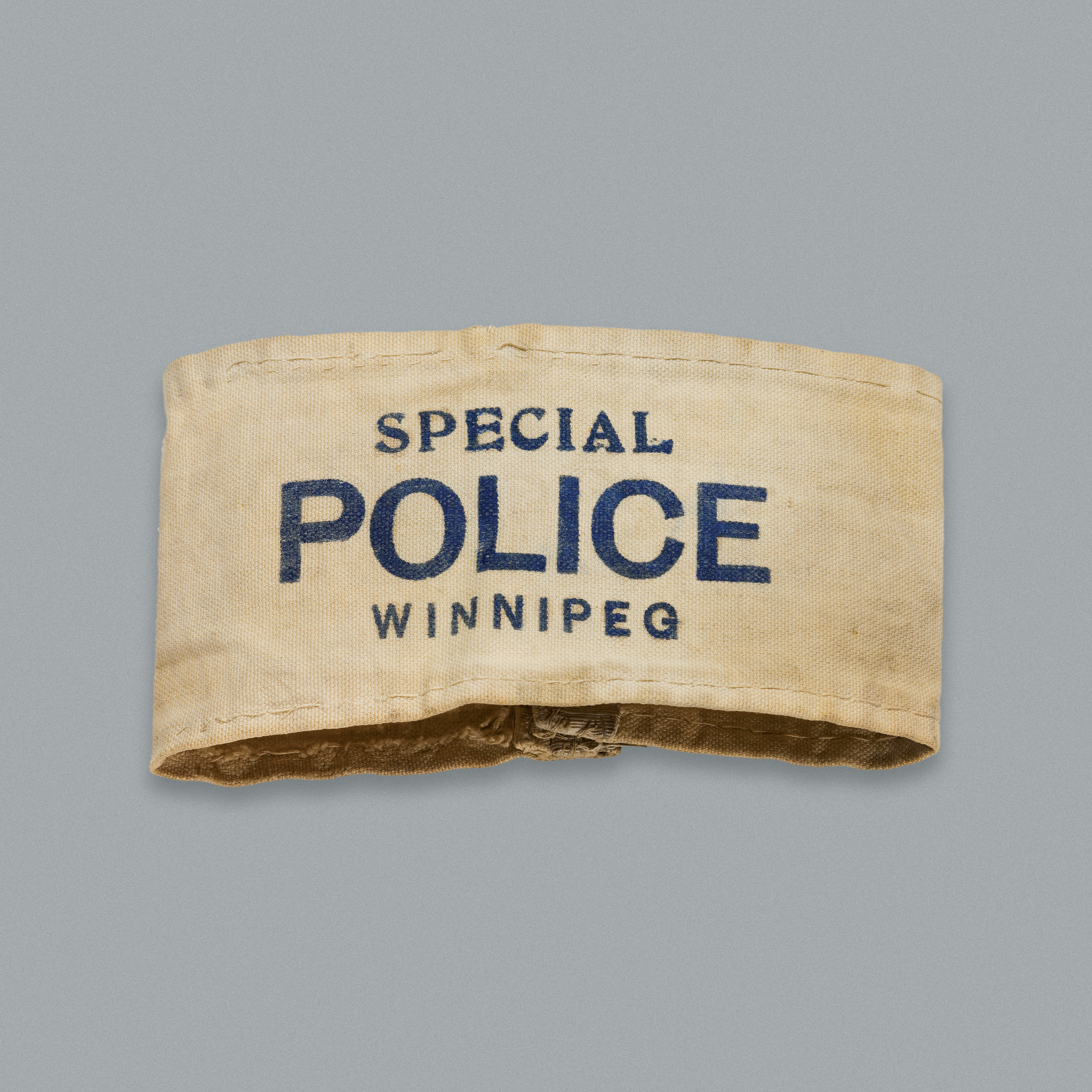 Brassard en coton blanc portant l’inscription « Special Police Winnipeg » (Police spéciale Winnipeg).//White cotton armband with “Special Police Winnipeg” on it