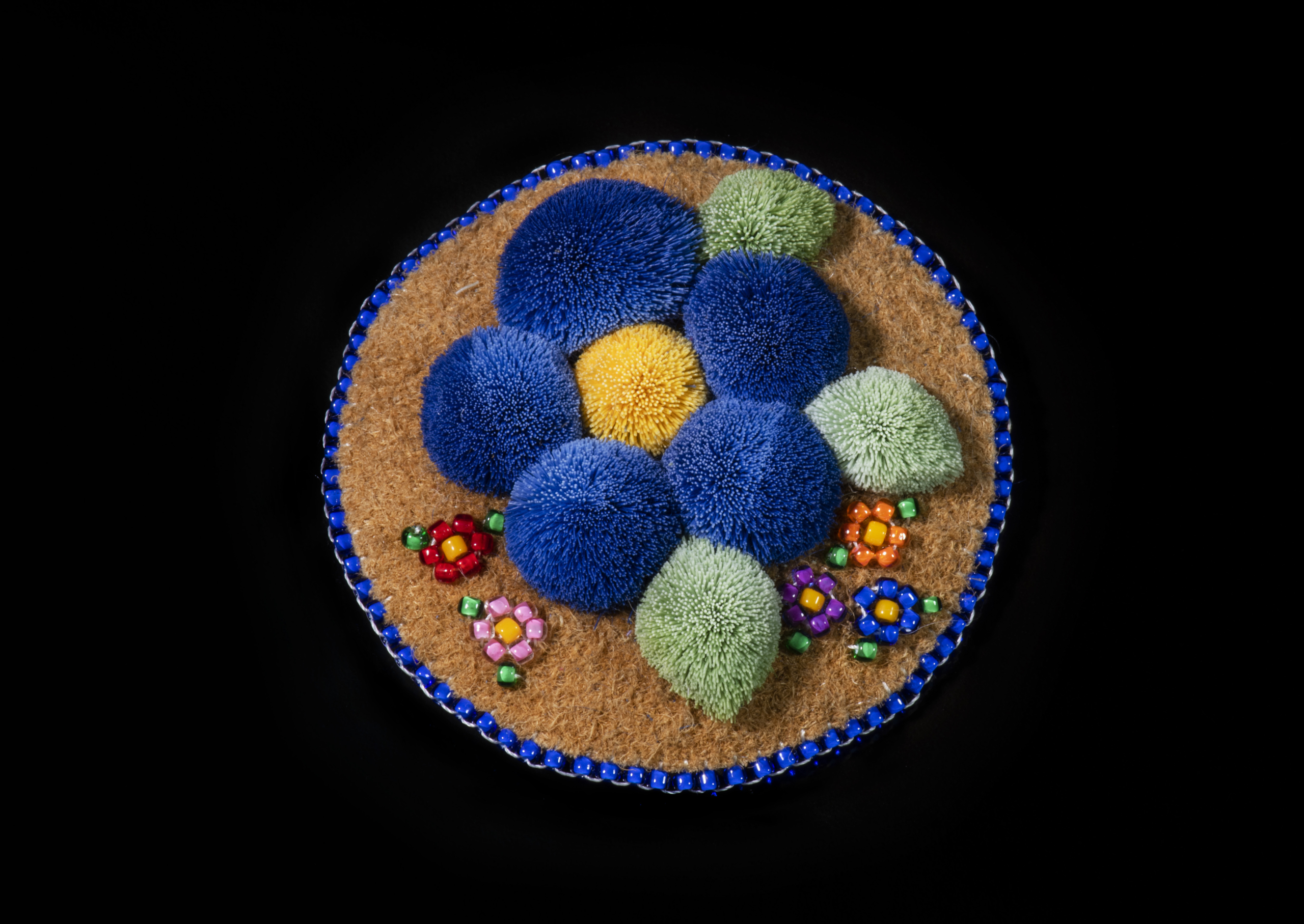 Moose hair tufted flowers on a tanned hide backing