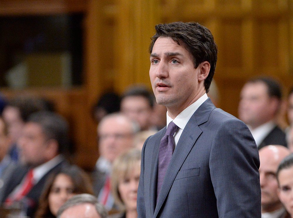 Le premier ministre Justin Trudeau s’exprimant sur un podium. Prime Minister Justin Trudeau speaking at a podium.