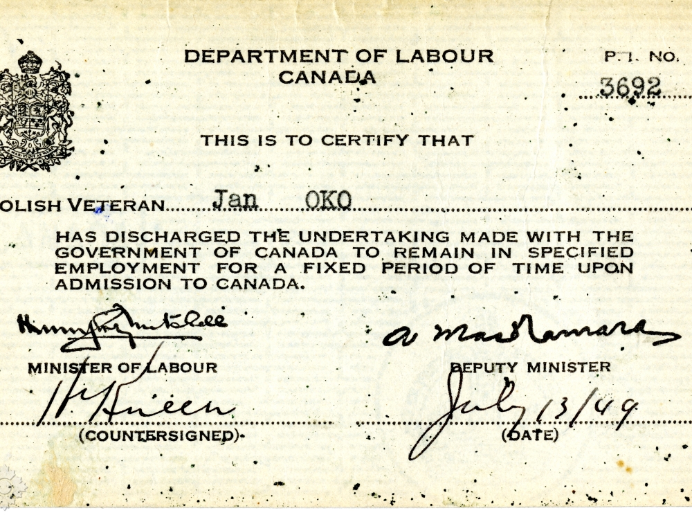 Une petite carte d’identité blanc cassé avec les armoiries du Canada en noir, des caractères noirs, des signatures en noir, une date manuscrite et l’en-tête « Department of Labour » (ministère du Travail).